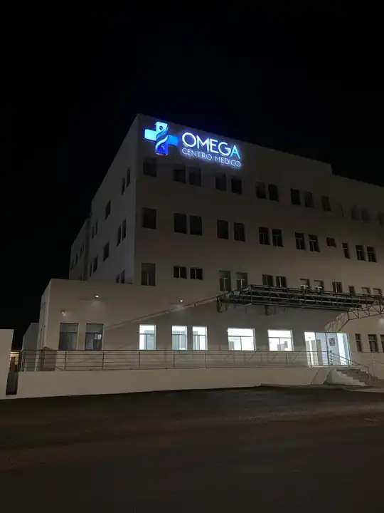 Letrero luminoso de Omega Centro Médico de noche